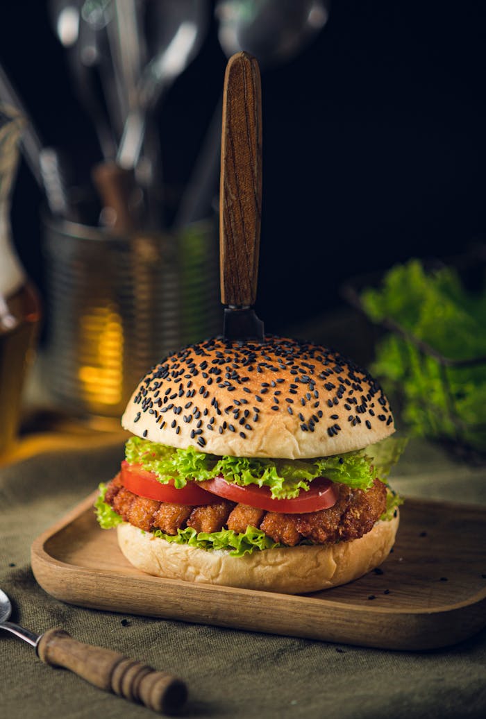 Mouth-watering crispy chicken burger with fresh veggies on a black sesame bun.